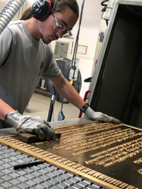 SLAM intern Mitch Hoffman buffs a plaque at Gemini