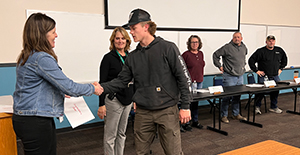 Student Jake Rodgers shakes hands with Learn and Earn Coordinator Liz Diggins.