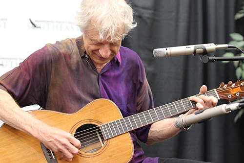 Phil Heywood playing a guitar