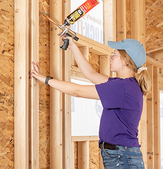 Woman applying sealant a construction site