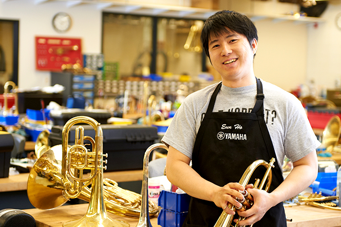 Student standing in a brass insturment shop