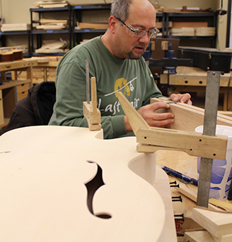 Student examining a guitar fretboard