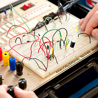 Hands working with an electonics 'bread board'