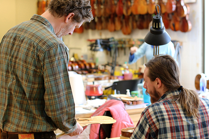 Instructor and student working in a violin shop