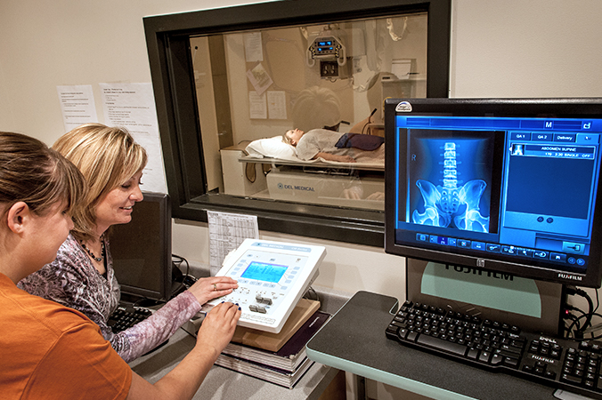 Instructor and student at radiology equipment