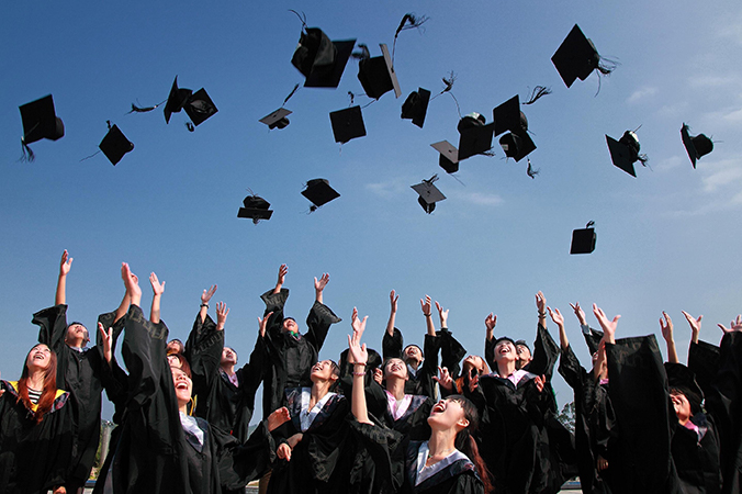 Graduates throwing their caps up in the air