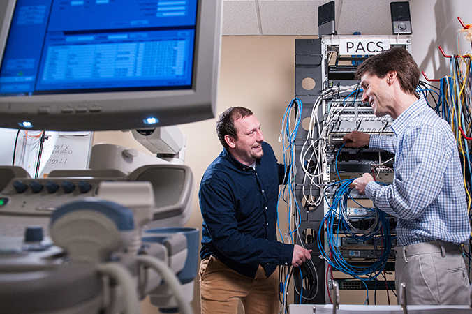 Two technicians working on server rack