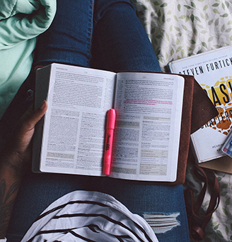 Open book on a person's lap with a highlighter