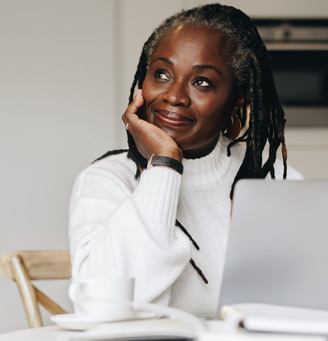 Woman sitting in front of a laptop and smiling