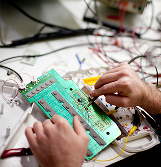 Hands of a technician working on a circuit board