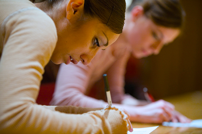 Two students writing - close up