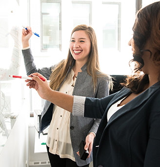 Two women working at a whiteboard