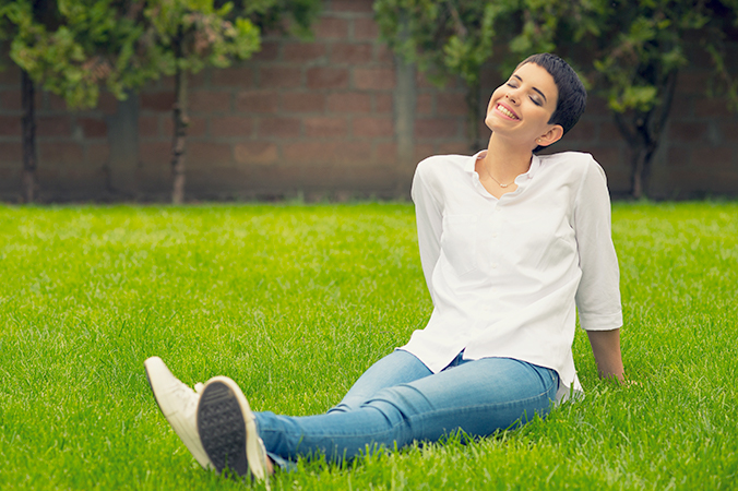 Woman smiling while sitting in the grass